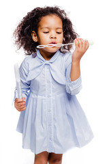 Wall Mural - Little pretty fashionable african american girl in blue dress blowing soap bubbles on white background