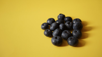 Delicious fresh blueberry on yellow background, space for text