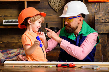 Wall Mural - Tools construction. Father teaching little son to use carpenter tools and hammering. Father helping son at workshop.