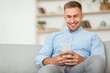 © Prostock-studio - Cheerful adult man using smartphone at home