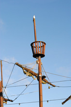 Close Up Of Mast & Crows Nest On Children's Wooden Pirate Ship In Playground Against Blue Sky 