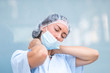 © cineberg - Neck muscle strain. Portrait of a tired and suffering doctor woman massaging her painful neck