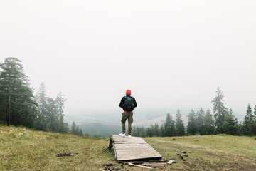 Wall Mural - Nature explorer enjoying the view of  a foggy mountain range