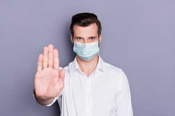 Poster - Close-up portrait of his he attractive healthy strict guy medic wearing safety gauze mask showing palm stop sickness illness disease mers cov pandemia isolated over gray color background