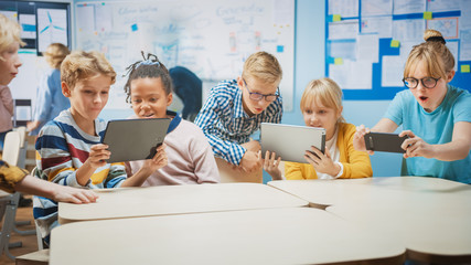 Wall Mural - School Computer Science Class: Schoolchildren Use Digital Tablet Computers and Smartphones with Augmented Reality Software, They’re Excited, Full of Wonder. Children in STEM, Playing and Learning