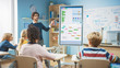 © Gorodenkoff - Elementary School Computer Science Teacher Uses Interactive Digital Whiteboard to Show Programming Logics to a Classroom full of Smart Diverse Children. Computer Class with Kids Listening