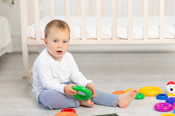 little boy 2 years old playing near the crib, early development