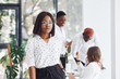 © standret - Portrait of woman in glasses. Group of african american business people working in office together