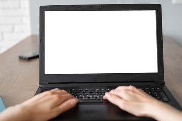 laptop with blank screen on white table with blurred background as concept. two hands are typing tex