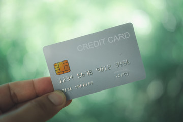 Hand holding white plastic credit card. Online shopping.