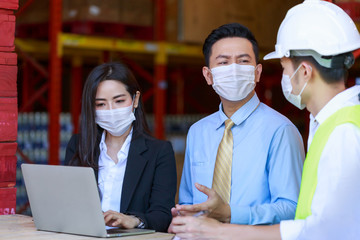 Portrait of attractive Asian businessman and investor woman, engineer, wearing protective face mask in warehouse, new normal after Coronavirus pandemic.