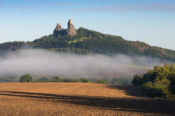 Poster - Ruins of old castle Trosky in Bohemian Paradise, Czech Republic. Ruins consist of two devasted towers on the woody hill. Morning landscape with misty atmosphere