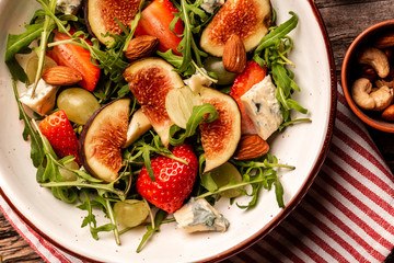 Diet menu. Healthy salad of fresh Fig, arugula, strawberries, grapes, blue cheese salad, Flat lay. Top view