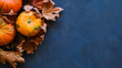 © meteoritka - Pumpkins and autumn maple leaves on dark blue background. Thanksgiving day concept. 16x9 banner, copy space.
