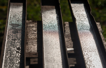 three wet rusty channels on a wooden workbench