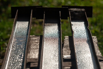 three wet rusty channels on a wooden workbench