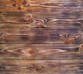 Dark old brown wooden pine background. Texture. View from above. Unprocessed boards.