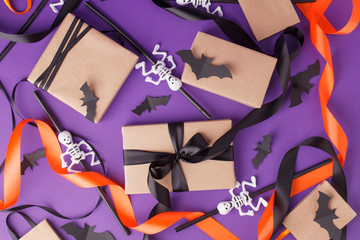 Wall Mural - Halloween gift boxes with ribbon and paper decoration on traditional purple background. Holiday, Birthday, Halloween party celebration concept, seasonal sale, black friday, preparation for party