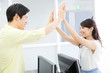 © Paylessimages - ハイタッチする男女の会社員