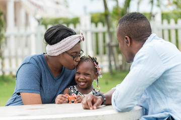 Happy African mother play with daughter in family relax in outdoor garden.