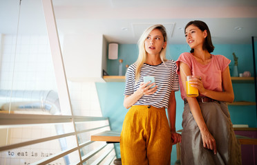 Wall Mural - Friendship, happiness and people concept. Young women talking and having fun together