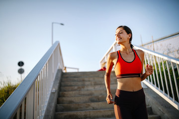 Wall Mural - Portrait of a cheerful young sports woman outdoor