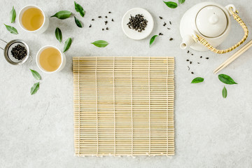 Wall Mural - Herbal tea with two white tea cups and teapot, with green tea leaves. Flat lay, top view. Tea concept