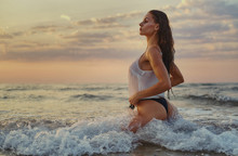 Sexy Woman Posing On Beach Near The Sea At Sunrise
