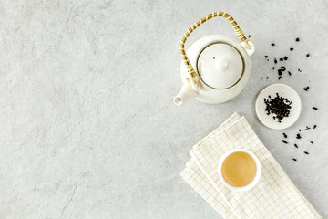 Herbal tea with two white tea cups and teapot, with green tea leaves. Flat lay, top view. Tea concept