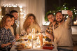 © Syda Productions - holidays, celebration and people concept - happy friends taking selfie by smartphone at home christmas dinner party