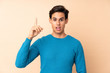 © luismolinero - Man over isolated background intending to realizes the solution while lifting a finger up