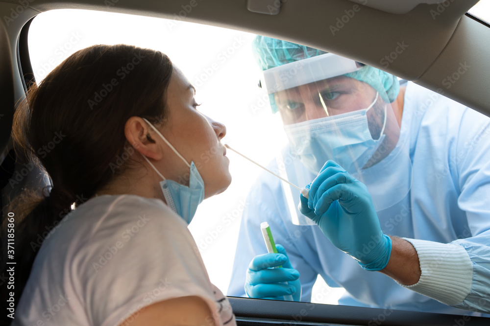 Woman getting tested at a coronavirus drive thru station - obrazy, fototapety, plakaty 