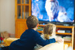 © Irina Schmidt - Cute little toddler girl and school kid boy watching animal movie or movie on tv. Happy healthy children, siblings during coronavirus quarantine staying at home. Brother and sister together. no face