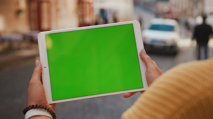 Close up hands woman using tablet device computer with green screen outdoors in street at sunlight horizontal bloom message pad technology chroma key female digital girl app chat finger mock up
