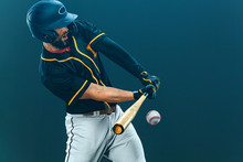 Baseball Player With Bat Taking A Swing On Grand Arena. Ballplayer On Dark Background In Action.