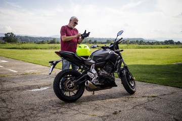 Wall Mural - A middle-aged man enjoys with his motorcycle