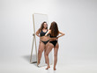 © master1305 - Young fit, slim woman looking at fat girl in mirror's reflection on white background. Thinking she's not enough sportive. Concept of healthy lifestyle, fitness, sport, nutrition and body positive.