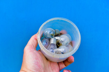 Small dusty incandescent lamps in a jar on a blue background