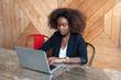 © Viktor Solomin/Stocksy - Beautiful black african american business woman are sitting at the table with a laptop, working