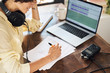 © guille Faingold/Stocksy - Crop podcaster editing script near laptop