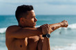 © HEX./Stocksy - Male Athlete Stretching After Sport Training on the Beach Close to the Sea. Front View with Large Copy Space