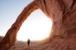 Person looking through Corona Arch at Sunset, near Moab Utah
