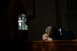 © Julia Forsman/Stocksy - Man bows his head in prayer in Church.