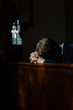 © Julia Forsman/Stocksy - Man bows his head in prayer in Church.