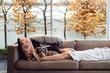 © Angela Lumsden/Stocksy - Companionable dog resting on a couch with his owner
