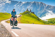 Cyclist on the road in scenic caucasus nature with Gergeti trinity monastery in the background. Traveller on bicycle,