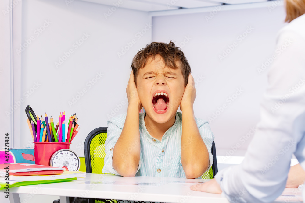 Boy with autism disorder scream and close ears in pain during ABA ...