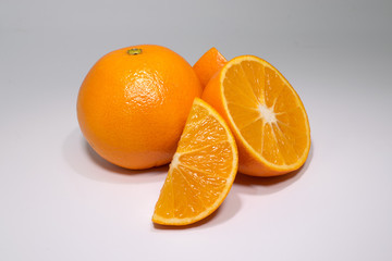 set of two oranges, one whole and the other cut in half