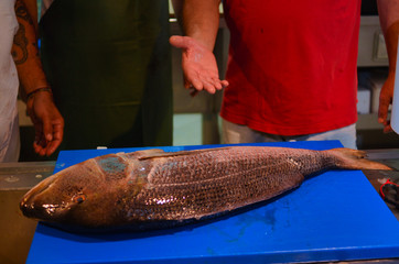 Man cleaning fresh fish from mediterranean sea at the fisherman market