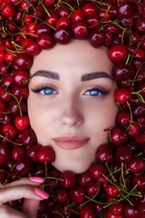 woman beautiful face with red ripe big fresh cherry